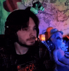 a man wearing headphones and a shirt that says ' rock ' on it sits in front of a map