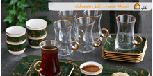 a set of glasses and bowls on a green tray with arabic writing