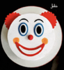 a cake with a clown face on it on a plate