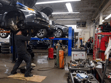 a man in a black shirt is working on a car