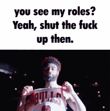 a man wearing a bulls jersey holds his fist up in the air