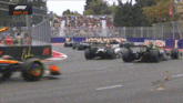 a row of race cars on a race track with a sign that says replay