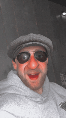 a man wearing sunglasses and a hat makes a face