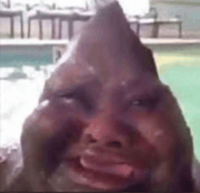 a close up of a person 's face with a triangle on it and a pool in the background .