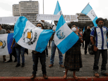 a group of people are holding up flags and signs that say remunden