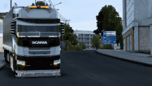 a scania truck is driving down a street