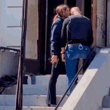 a man and a woman are kissing on the steps of a building that has the word open on it