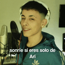 a young man wearing headphones stands in front of a microphone with the words sonrie si eres solo de ari on the bottom