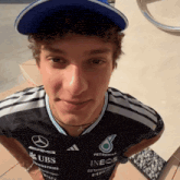 a young man wearing a shirt that says ubs and ineos
