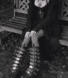 a woman in a black dress is sitting on a bench