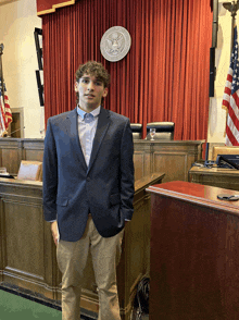 a man in a suit stands in front of a podium with the seal of the united states of america