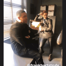 two men in suits are standing next to each other in a room with frankhartstruly written below them