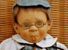 a doll with glasses and a hat is sticking out its tongue