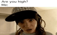 a woman wearing a hat and dreadlocks is asking are you high .