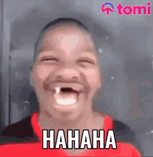 a man with a missing tooth is laughing with his mouth open and a red shirt on .