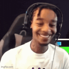 a man wearing headphones is smiling and looking at the camera .