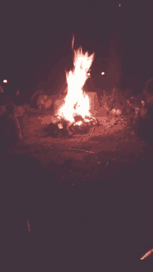 a large fire is burning in the middle of a field at night