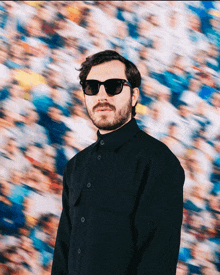 a man with a beard wearing sunglasses and a black shirt