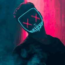 a man wearing a neon mask with crossed eyes and stitches on his face .