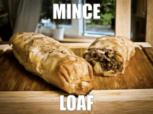 a loaf is sitting on a wooden cutting board next to a mince