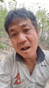 a man wearing a white shirt with a nepal flag on it is making a funny face