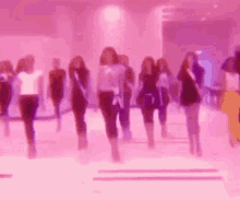 a blurry picture of a group of women walking in a room .