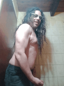 a shirtless man with long hair is wearing sunglasses and smiling