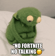 kermit the frog is sitting on a bed with a sad face and the words " no fortnite no talking "