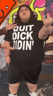 a man wearing a black shirt that says quit dick ridin '