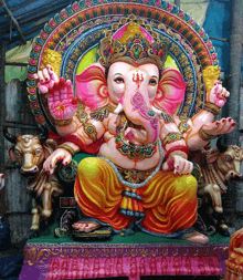 a colorful statue of ganesha sitting on a throne