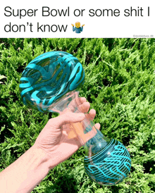 a person is holding a blue glass pipe with the caption super bowl or some shit i don 't know