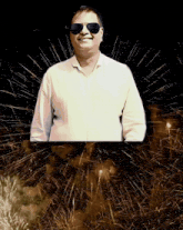 a man wearing sunglasses stands in front of a firework display