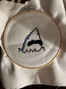 a cross stitch of a shark 's mouth is being worked on