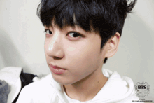 a close up of a person 's face with the letters bts on the bottom