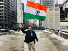 a man in a black jacket is holding up a flag