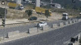 a gif from gifrun.com shows a car driving down a street