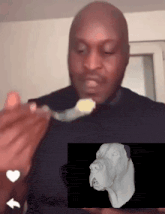 a man is eating something with a spoon and a picture of a dog is behind him