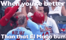 two baseball players are giving each other a high five in front of a crowd at a baseball game .