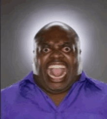 a bald man in a purple shirt is making a funny face