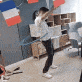 a man is playing with a hula hoop in a room with french flags on the wall