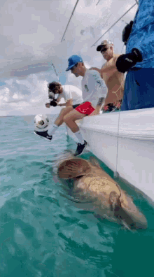 a group of men are fishing in the ocean and one of them is wearing a shirt that says ' adidas ' on it