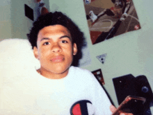 a young man wearing a white shirt with the word champion on it