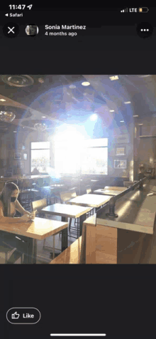 a phone screen shows a photo of sonia martinez sitting at a table in a restaurant