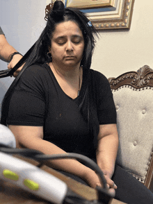 a woman with her eyes closed is getting her hair straightened