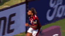 a soccer player is running on the field in front of a sign that says ' libertadores ' on it .