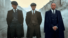 three men in suits and hats standing on a street