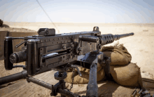 a machine gun sitting on top of a sand bag