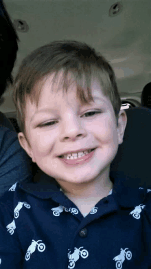 a young boy wearing a shirt with motorcycles on it