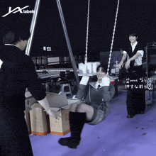 a person sitting on a swing with the letters jx labels on the bottom