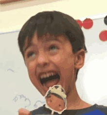 a young boy is holding a sticker of a boy with a crown around his head